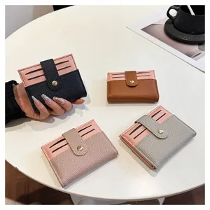 Vista dettagliata del mini portacarte da donna con design bicolore e chiusura a bottone a pressione.