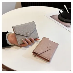 Vue détaillée du portefeuille pliable en cuir PU style enveloppe en gris et rose avec bouton.