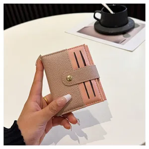 Dettaglio del mini portafoglio da donna bicolore chic, con bottone a pressione e fessure per carte.