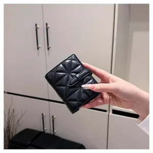 Dettaglio di portafoglio corto nero in PU da donna con elegante motivo trapuntato.