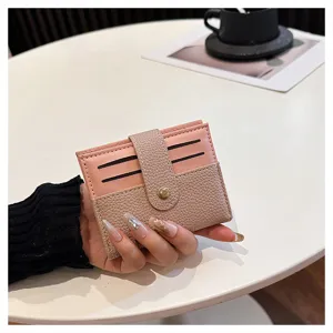 Primo piano dettagliato del portacarte mini da donna con design bicolore e chiusura a pressione.