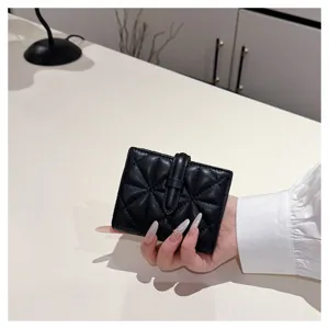 Primo piano sui dettagli del portafoglio nero in PU trapuntato con cuciture raffinate.