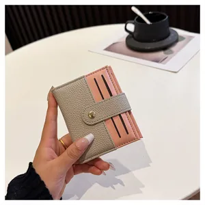 Dettaglio del mini porta carte bicolore da donna con chiusura a pressione e scomparti.