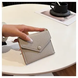 Gros plan sur le petit portefeuille en cuir PU gris, accessoire minimaliste de détail.