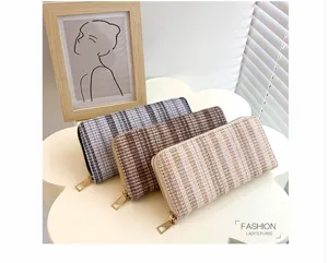 Detailopname van tweed lange portemonnee met meerdere kaartvakken en ritssluiting.