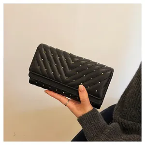 Portafoglio lungo trapuntato nero da donna con borchie dorate, elegante design a tre ante.