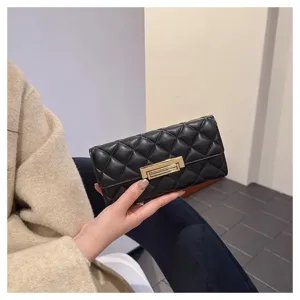 Primer plano de la cartera acolchada negra que muestra textura suave y cierre dorado.