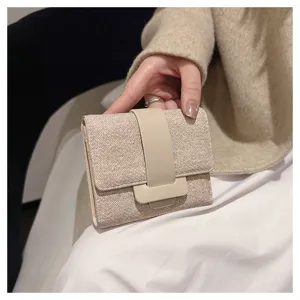 Tri-fold wallet for women, compact design with snap closure and stylish fabric texture.