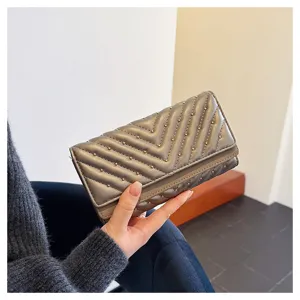 Portafoglio lungo grigio vista dettaglio, design matelassé chevron con borchie.