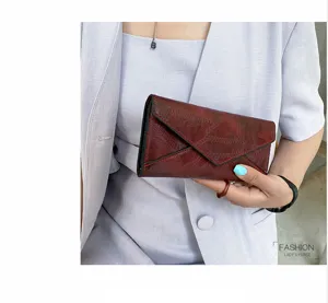 Women wine red long envelope wallet detail showing soft leather texture and card slots.