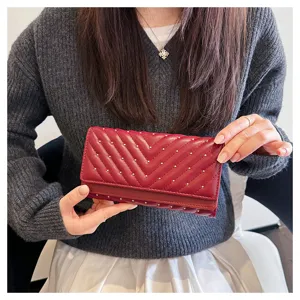 Portafoglio lungo rosso da donna con trapuntatura Chevron e borchie dorate, design a tre ante.