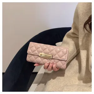 Primer plano del elegante monedero largo acolchado rosa con detalle de cierre metálico.