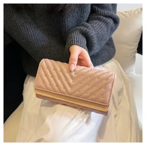Lungo portafoglio trapuntato da donna con borchie, chic design a tre ante elegante.