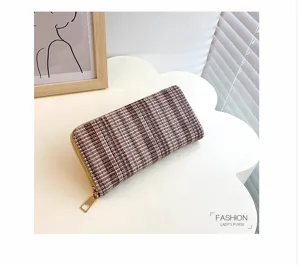 Detailopname van een stijlvolle lange tweed portemonnee met gouden ritssluiting.