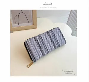 Gedetailleerd overzicht van de zwart-grijze tweed portemonnee met rits en gouden hardware.