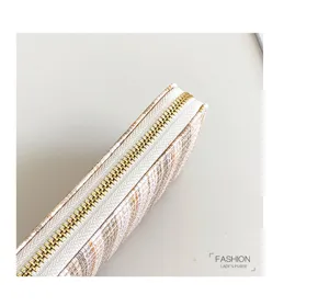 Detailopname van de getextureerde portemonnee-rits, met gouden metalen tanden en stof.
