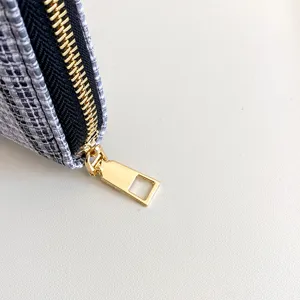 Close-up van een stijlvolle damestextuur lange portemonnee clutch met een gouden rits.
