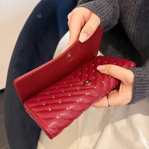 Portafoglio lungo donna rosso trapuntato chevron con borchie chic e chiusura a scatto.