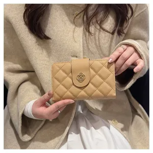 Portefeuille matelassé court pour femme, design beige élégant avec fermoir métallique et cartes.