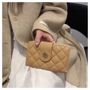 Vue détaillée du portefeuille court matelassé beige pour femme avec fermoir métallique élégant.