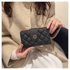 Élégant portefeuille court matelassé noir pour femme avec doublure rouge et fermoir doré chic.