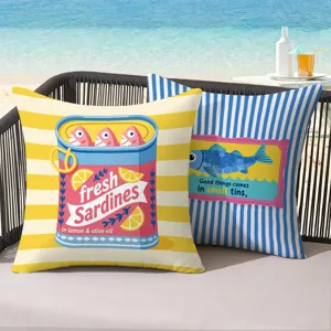Close-up detail of retro sardine canned print throw pillow cover on outdoor beach sofa.