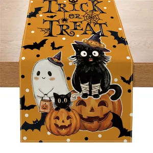 Halloween table runner detail with cute black cat and pumpkin print, festive holiday home decor.