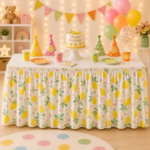 Detailaufnahme des Tischrocks mit Zitronenmuster, Falten-Design und fröhlicher Sommerdeko.