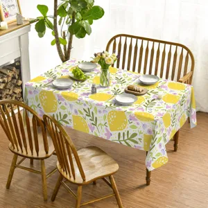 Detailed close-up view of the vibrant lemon floral tablecloth on a rustic wooden dining table.