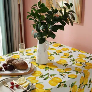 Detailed view of fresh lemon print tablecloth styled on a warm home dining table setting.