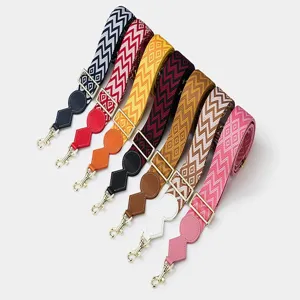 Close-up detail of colorful woven wide shoulder straps with geometric patterns and metal hooks.