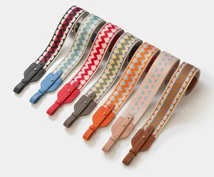 Wide woven bag strap with colorful zig-zag pattern and leather ends for shoulder bags.