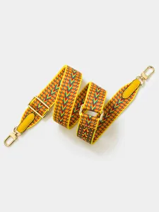 Close-up of a colorful woven replacement shoulder strap with gold hardware and leather tabs.