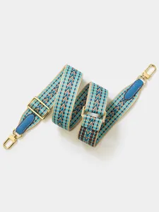 Detailed view of the woven shoulder strap showcasing adjustable metal buckles and hooks.