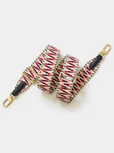 Gros plan de la bandoulière de sac tissée réglable avec motif géométrique et détails dorés.