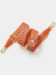 Details of the orange chevron replacement shoulder strap with gold hardware for crossbody bags.