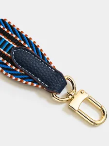 Bunter gestreifter Ersatz-Taschenriemen Detail, hochwertiger Leder-Tab und goldener Karabiner.