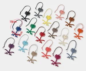 Close-up detail of luxury genuine leather palm tree bag charms, multi-color keychain accessories.