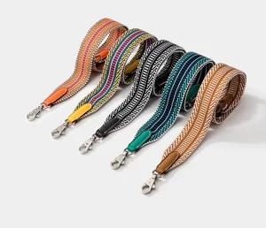 Colorful woven replacement bag strap with leather ends and metal clasps, wide geometric design.