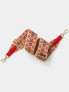 Detailed close-up of adjustable woven shoulder strap with geometric pattern and gold hardware.
