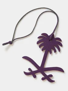 Premium leather palm tree bag charm detail shot, luxury key pendant decoration close up view.