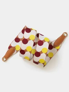Detailed view of a wide woven replacement bag strap with colorful dot pattern and leather ends.