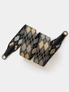 Close-up detail of a stylish wide replacement bag strap with classic argyle pattern and leather ends.