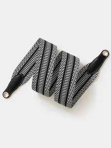 Close-up of black and white striped replacement bag strap with leather ends and metal eyelets.