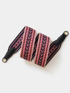 Woven replacement bag strap detail, colorful chevron pattern with leather ends and grommets.