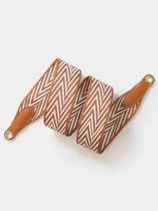 Close-up of the woven replacement bag strap, highlighting the textured pattern and hardware.
