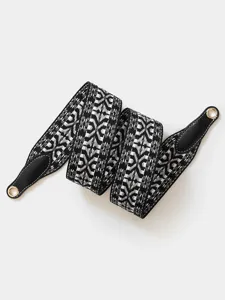 Black and white geometric pattern replacement wide bag strap with leather ends and metal eyelets.
