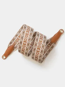 Detailed view of wide woven bag replacement strap with brown leather ends and metal eyelets.