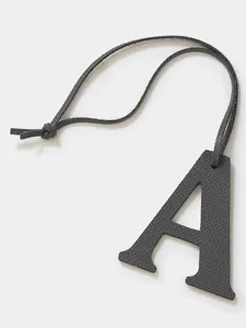 Black leather letter A charm detail, premium pebbled texture, stylish bag and key accessory.