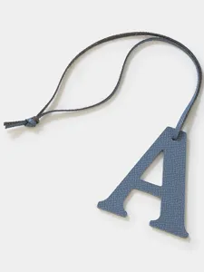 Blue leather letter A charm detail close-up, premium leather bag and key pendant.